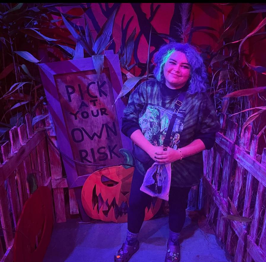 person stands in front of halloween decor